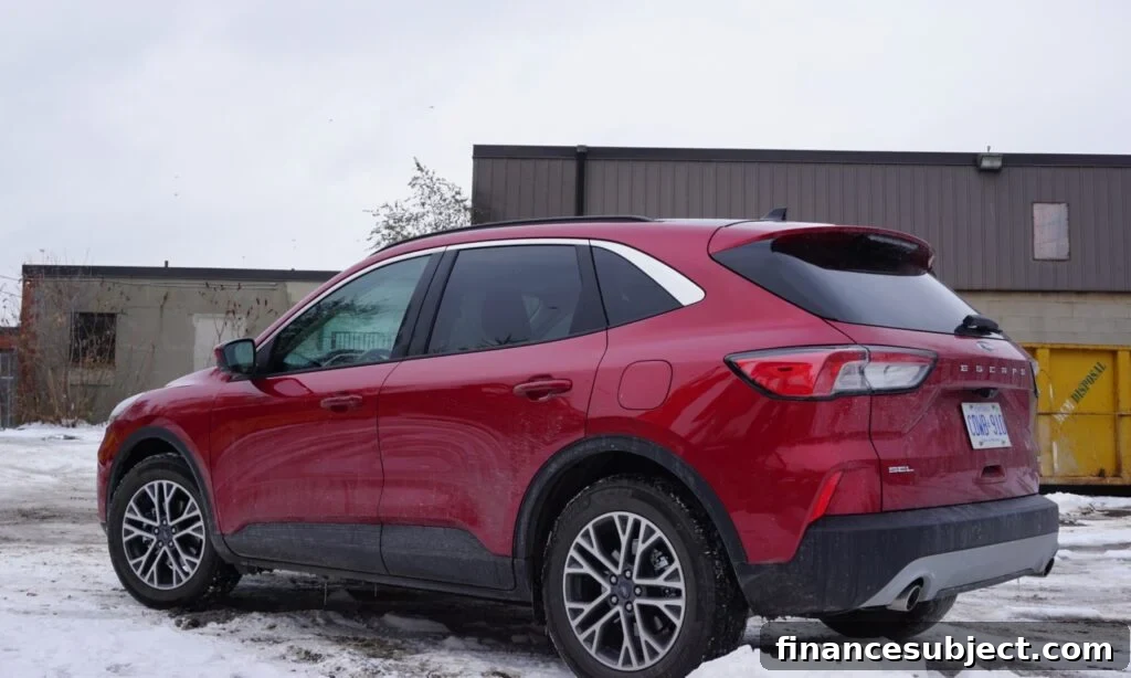 A red Ford Escape sits in a snowy parking lot