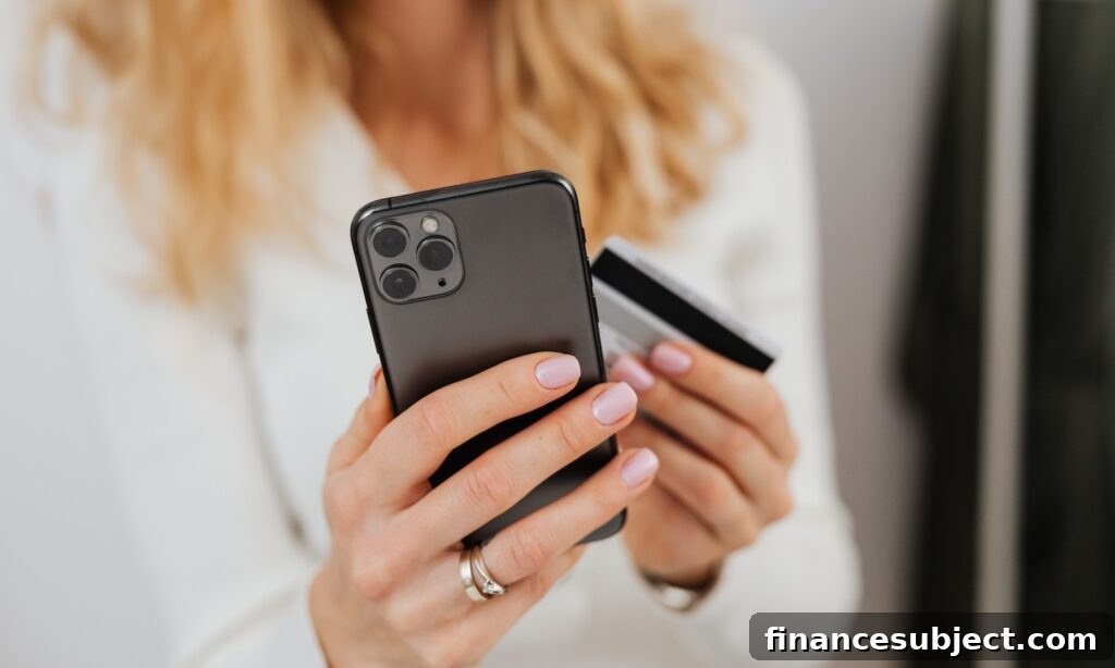 A woman holds her smartphone and a credit card