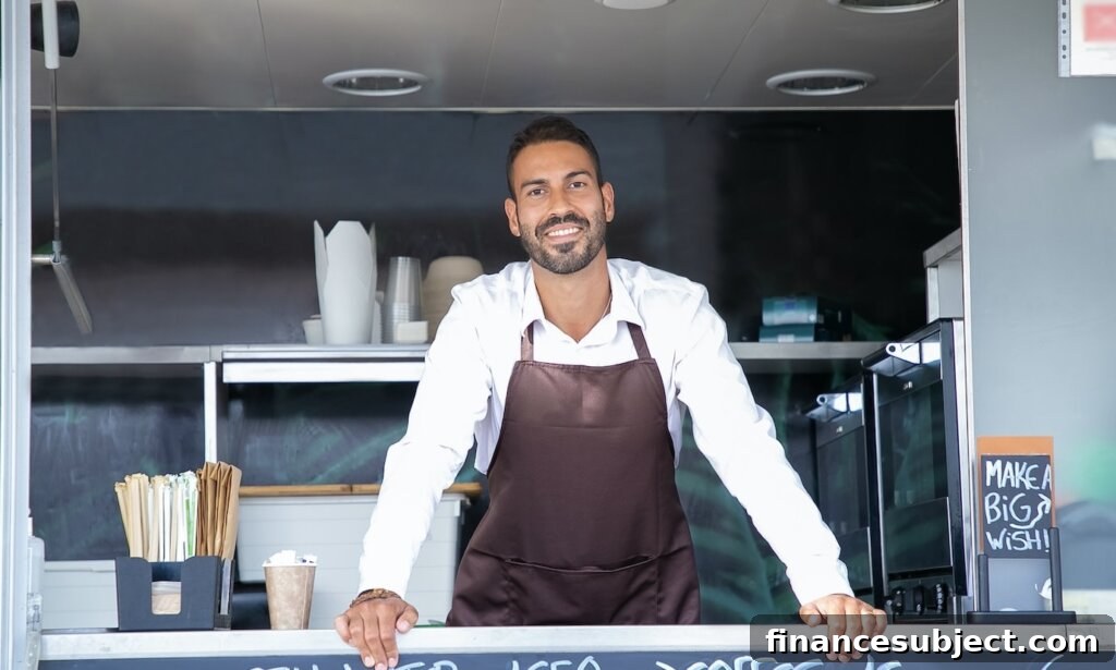 A smiling young man behind the counter of a food truck