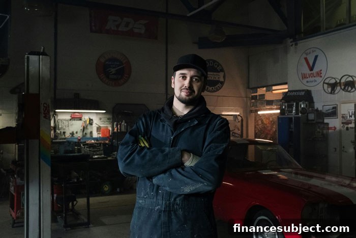 A young man stands in a car repair shop