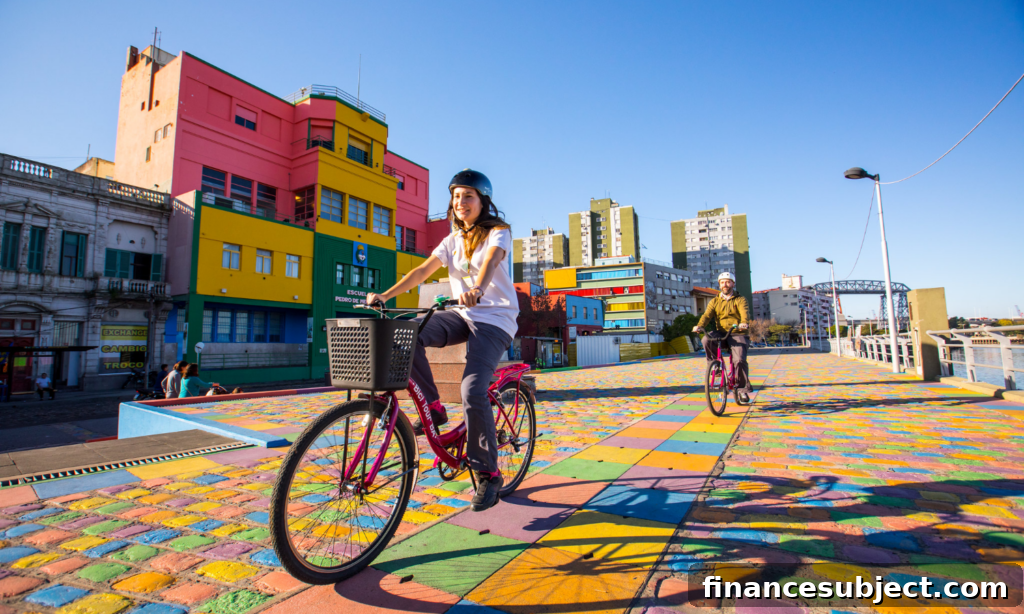 A man and woman ride bikes on a colourful boardwalk in Buenos Aires, Argentina