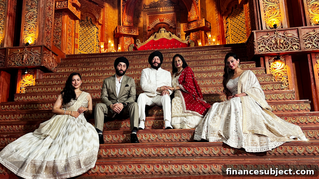 The Singh family sits on an ornate staircase, wearing beautiful Indian clothes
